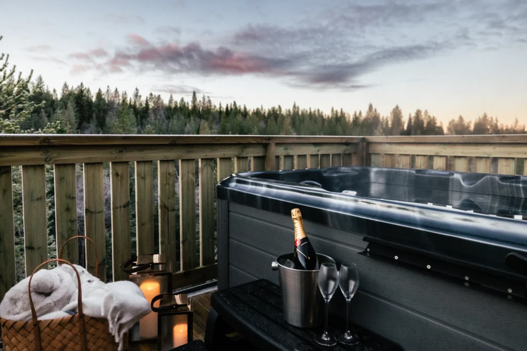 Private outdoor hot tub and champagne terrace overlooking the Arctic forest.